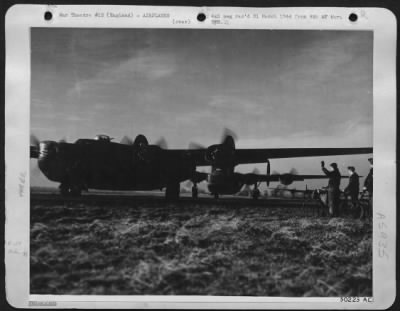 Thumbnail for Consolidated > Liberators, queue up on run-way ready to take off on proper signal. Some of bicycling ground crews are shown waving "good luck" to their flying mates.