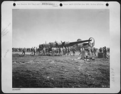 Thumbnail for Consolidated > Ground crews swarming around a bomber returning from a D-Day mission for informationon the invasion.