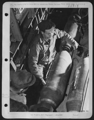 General > You are looking down from the radio room through the bomb bay of a U.S. Army 8th A.F. bomber. A couple of USAAF ordnance men are preparing two 500-lb high explosive bombs which are still on the bomb cart before being lifted into position and fixed