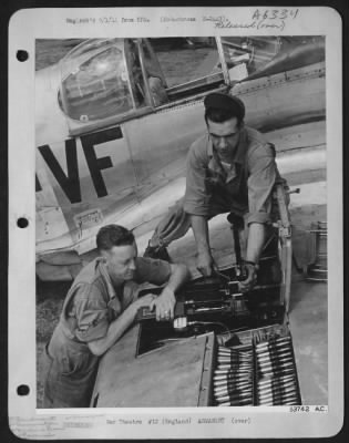 Thumbnail for General > ENGLAND-Left to right: Cpl. Burton Platt of Hattiesburg, Miss., and Cpl. Mel J. Wilton of Saginaw, Mich., both armorers, are shown removing live ammunition from .50 caliber machine guns in the wing of a P-51 fighter plane.