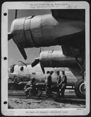 Thumbnail for General > 500-pounders are lifted by hand by Ordnance crew from bomb trailer to be placed onto cradle where fins are attached. A hand trailer is then  slipped under the cradle and wheeled to Consolidated B-24 bomb-bay. The bomb service truck with bomb trailer