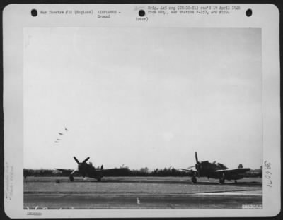 Thumbnail for Republic > High Above The Two Republic P-47'S Of The 353Rd Fighter Group, Parked Beside The Runway At A Base In England, A Flight Of P-47'S Peels Off For A Landing.