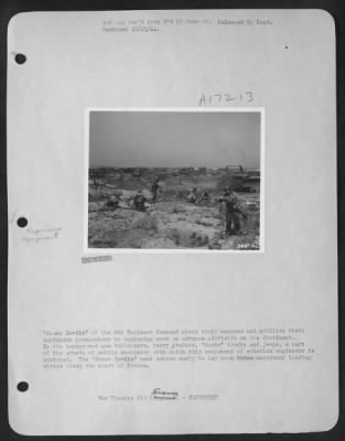 General > "Dozer Devils" of the 9th Engineer Command check their weapons and mobilize their equipment preparatory to beginning work on advance airfields on the Continent. In the background are bulldozers, heavy graders, "ducks" trucks and jeeps, a part