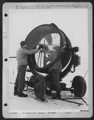 General > FRANCE--Sgt. Arthur Grahame, Akron, Ohio, left, and Pvt. James Nolin, Columbus, Ga., change carbons during a general check-up of their searchlight. To insure peek operational efficiency at night, the light is checked daily.