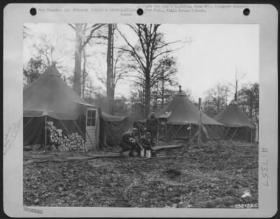 Thumbnail for Installations > Three Ninth Air Force soldiers with a little time to spare replenish their stock of fire wood. Left to right, the photo shows, Cpl Michael Davlik, Cleveland, Ohio; Sgt George L. Cruchfield, Springfield, Ala.; and S/Sgt Bert Hanlon, Beverly, Mass.