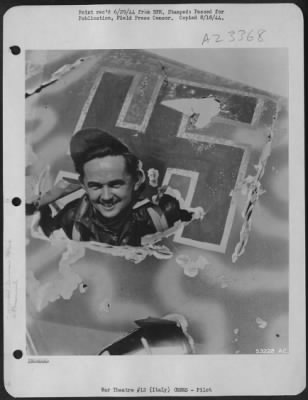 Thumbnail for Consolidated > 2nd Lt. Joseph R. Konieczny, 23 of 324 Ave. E. Bayonne, N.J., pilot of a 15th AAF Boeing B-17 Flying Fortress, wearing his good luck cap which is standard equipment for him on his combat missions, is shown here looking through a hole in the tail of a