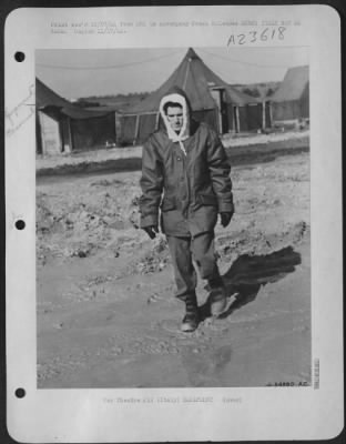 Thumbnail for Consolidated > Rigged out in a complete winter outfit, Sgt Sydney S. Gash, Brevard, N.C., a combat crewman, plows through Italian mud on his way back to his tent. He is wearing two pairs of gloves and he needs them-in "Sunny Italy." Sgt Gash says he doesn't know