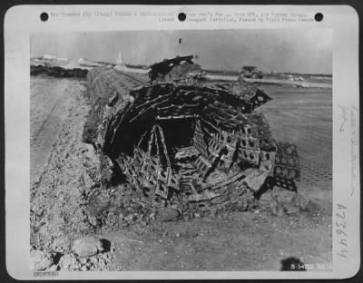 Thumbnail for Consolidated > ITALY-Although pierced steel plank forms an all-weather surface, the earth base under it is subject to the vagaries of Nature. Here an entire section of assembled plank runway is rolled back so that the base can be regarded. The planks will outlast