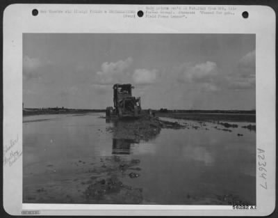 Thumbnail for Consolidated > Even while runways are still underwater, aviation engineers carry on the job of maintaining airfields to keep 'em flying, bombing and fighting. Here a motor patrol grader slogs through mud and water to level the surface. ITALY