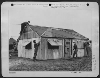 Consolidated > These busy pilots of a fighter squadron of Mediterranean Allied Air Forces in Italy, spend many hours of their spare time putting the finishing touches on the attractive bungalow they have built. Belly tank crates furnish material. Left to right: 1st