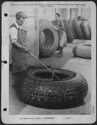 Thumbnail for Consolidated > Tire is washed clean, exposing deep cuts and area worn smooth during landings and take offs from improvised airfields and steel mats. Italian Work-man shown here is one of thousands of natives employed by the Army Air Force Service Command in Italy