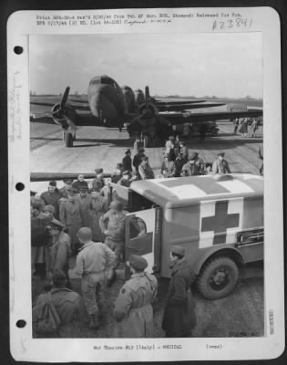 Thumbnail for Consolidated > Troop Carrier transports of the 9th USAF are lined up to receive hospitalized soldiers for removal to a general hospital several hundred miles distant. Patients are loaded by specially schooled air evacuation units.