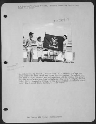 Thumbnail for Consolidated > Lt. Frieda Cox, 13 Main St., Mullica Hill, N.J. (right) displays the group colors she made for an AAF Flying Fortress group. The colors were made from salvaged material and old parachute silk to replace the group's original colors which were lost in