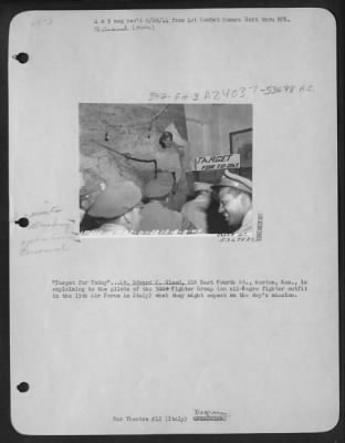 Consolidated > "Target for Today" . . . Lt. Edward C. Gleed, 216 East Fourth St., Horton, Kan., is explaining to the pilots of the Fighter Group (an all-Negro fighter outfit in the 15th Air Force in Italy) what they might expect on the day's mission.