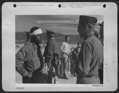 Consolidated > ITALY-Lt. Andrew D. Marshall, Bristol, Va., pilot in a Negro fighter group of the Mediterranean Allied Air Forces tells an American pilot how he escaped death when his plane was shot up by flak during a strafing mission over Greece before the Allied