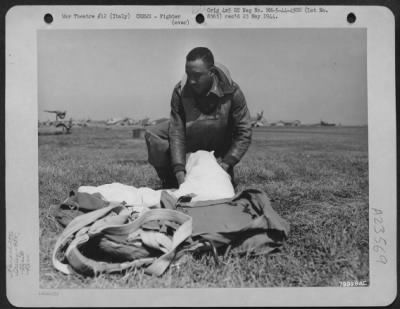 Thumbnail for Consolidated > Lt. Theodore A. Wilson, A Member Of The 99Th Fighter Squadron Based Somewhere In Italy, Rolls His Parachute After Successfully Bailing Out Of His Curtiss P-40 After It Was Badly Hit By Enemy Flak.  3 May 1944.