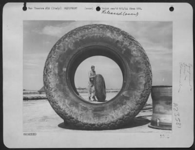 Thumbnail for Consolidated > Sgt. R.G. Stallmeyer, 321 Trevor St., Covington, Ky, A Ground Crewman At A Boeing B-17 "Flying Fortress" Base In The 15Th Af, Italy, Is Framed By A 150 Pound Airplane Tires As He Rolls Another One.  [The Pictured Shows Two Good Reasons For Rationing Tires