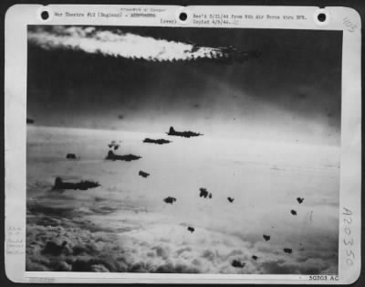Consolidated > FORTRESS ON FIRE OVER BERLIN--A Flying Fortress with smoke pouring from a fire in one of its engines continues on in formation during large-scale attack on Berlin by US 8th Air Force heavies on 22 March. Intense flak was encountered over the target