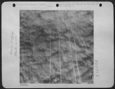 Thumbnail for Consolidated > Following the same path as the "marker" bombs, several sticks of high explosive bombs cascade into a dense layer of clouds over a target in Germany. The bomber formations must remain above the clouds to keep out of the extremely effective range of