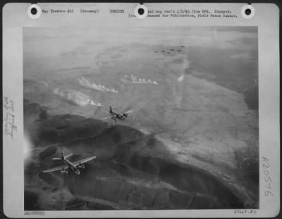 Consolidated > First Tactical Air Force Martin B-26 Marauders of the oldest medium bombardment group in the AAF wing over the Siegfried line northeast of Wissembourg while below them smoke rises from artillery shells fired by the army to mark the enemy defenses.