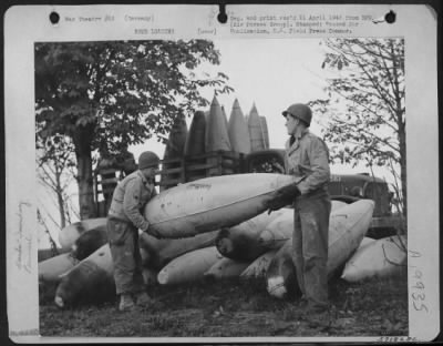 Thumbnail for Consolidated > Ground Crewmen Unload Captured German Belly Tanks Preparatory To Loading The Containers With Gasoline And A Jell Like Substance Which Will Convert Them Into A New Type Incendiary Bomb For Fighter Bombers Of Major General Hoyt S. Vandenberg'S 9Th Af.  L To