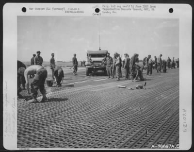 Consolidated > Pierced Steel Plank Is Laid On The Runway By Members Of The 834Th Engineer Aviation Battalion During Construction Of An Airfield At Furth, Germany.