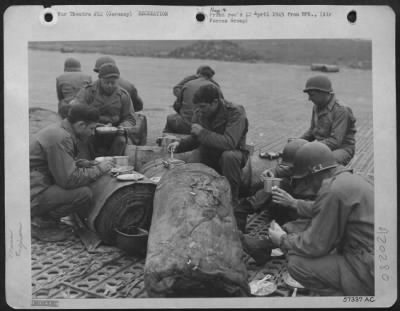 Thumbnail for Consolidated > Aviation Engineers Of The Ix Engineer Command, Building An Airstrip In Germany For 9Th Af Fighter Bombers, Have Their Noonday Chow In The Open.  Food Is Served On The Line With Rolls Of Prefabricated Bituminous Surfacing (Pbs) As "Tables."