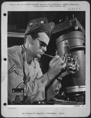 Thumbnail for Consolidated > The operation of the large aerial camera at the right is controlled by the mechanism being adjusted by Cpl. Charles F. Wald, 26, of RFD #3, Cincinnati, Ohio. Known as an intervalometer, this device automatically checks the camera shutter at