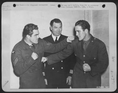 Thumbnail for Consolidated > Commander Jack Dempsey of the U.S. Coast Guard, center, gives the nod to Cpl Billy Conn of the U.S. Army Air Service Command (right) as he squares off with light-heavyweight champion of England, Sgt Freddie Mills. According to Dempsey, "The