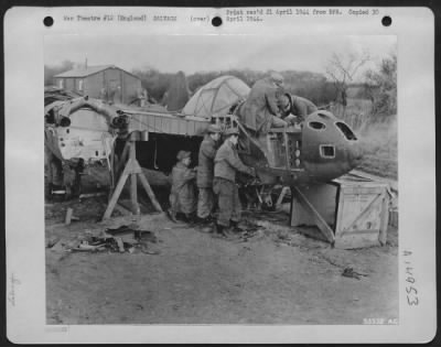 Thumbnail for Consolidated > Like vultures swarming over their prey, these mechanics prepare to strip a crashed warplane at an Air Service Command advanced depot in England. They make sure all useful parts are salvaged before the twisted metal shell is remelted. No waste here