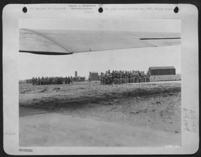 Thumbnail for Consolidated > Groups of 9th AF Service Command flying "Fixits," completely armed and equipped, are pictured from beneath the wing of a Douglas C-47 transport plane as it arrives to carry them forward to an advanced base somewhere in England. These skilled