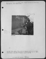 Pfc Emma Utter, Sagola, Mich., puts the finishing touches of a 16 hour painting job on the flak scarred hull of "Pallas Athene, the G.I. Jane," first bomber in the ETO to be named in honor of the WAC. - Page 1