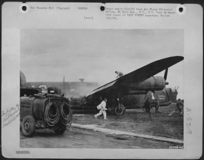 Thumbnail for Consolidated > Liberator with wing and engine blazing, gets fast, expert treatment from crash crew at base in England. Five ME-109s jumped the B-24, puncturing tire with 20 mm burst and knocking out the hydraulic system. Tail gunner got one ME, found ofrty 20 mm