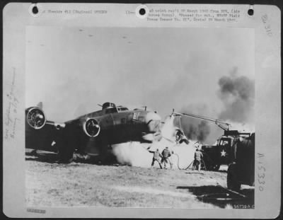 Thumbnail for Consolidated > ENGLAND, March 21, 1945-Fire fighters working to extinguish fire fast consuming the left wing of a Boeing B-17 Flying ofrtress. Only one member of the plane's crew was slightly injured.