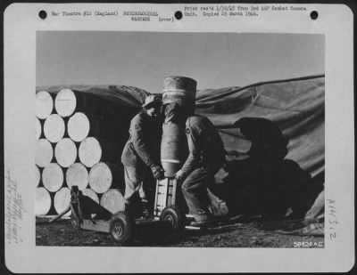 Consolidated > Capt. John V. Keck, Ordnance Officer At The Chelveston Air Base Designed And Constructed An Inexpensive Bomb, Using M-76, 500 Lb. Cluster Bomb Casing, To Facilitate And Improve The Accuracy Of Propaganda Leaflet Bombing.  Shown Here Are Two Ordnance Men P