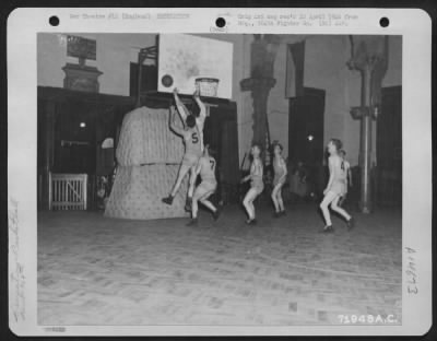 Thumbnail for Consolidated > During The Heat Of A Basketball Game, Played By Men Of The 364Th Fighter Group, 67Th Fighter Wing, A Player Makes A Shot For The 'Bucket' As A Guard Tries To Knock The Ball Out Of Position.  8Th Air Force Station F-375, Honnington, England.  11 December 1