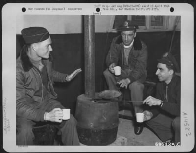 Thumbnail for Consolidated > Three Officers Of The 353Rd Fighter Group Exchange Stories Of Their Experiences In Combat As They Drink Hot Coffee Inside A Shack At Their Base In England.  April 1944.