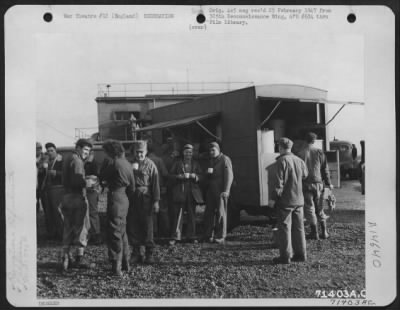 Thumbnail for Consolidated > Line Personnel Of The 390Th Bomb Group Stand Around A Red Cross Clubmobile Eating Doughnuts And Consuming Hot Coffee At An 8Th Air Force Base In England.  24 October 1943.