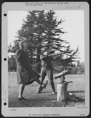 Thumbnail for Consolidated > 2Nd Lt. Mark Schneider, Chicago, Ill., Stands Ready To Blast The Clay Pigeon Which Miss Sally Burke, American Red Cross Worker, Just Released With Her Foot, At A Rest Home At Salisbury, England.  2 February 1944.