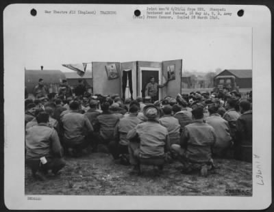 Consolidated > England - Sgt. Harold Scott Of Fremont, Mich., Instructor For A Mobile Mines And Booby-Traps School, Demonstrates Some 'Boomph Girls' Pin-Up Photos With Booby Traps Attached.  One Touch And There'S Another Dead Soldier.  Needless To Say The Class At This