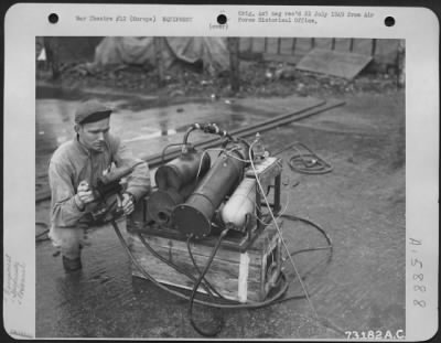 Thumbnail for General > Gi Ingenuity Takes Strange Twists - Gi Gadgets Have Saved Many Hours And Made Tedius Tasks Easier.  Here, S/Sgt. George E. Rupp Of Cleveland, Ohio, Demonstrates A Device For Distilling Water Which He Made From Scrap Parts Found Around An Airbase.  Large Q