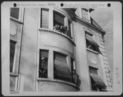 Thumbnail for General > These American soldiers of the 3rd Army, among the first to enter Metz after the city fell 11/22/44, are prepared for any eventuality. While one unit of soldiers emplaces a machine gun in a window (lower center), two other GIs chat with a pair