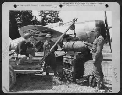 Thumbnail for General > 1st Lt. F.G. Tuscher (left) Auburndale, Mass., ordnance and transportation officer of a 9th Air force unit in France, supervises the operation of a hoist he made of captured German material to aid in the speedy loading of bombs on Republic P-47