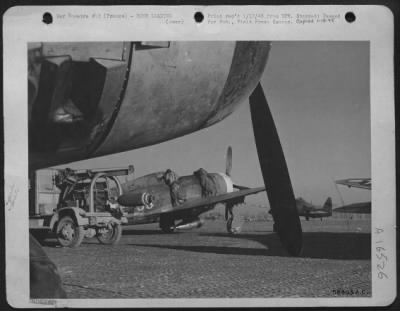 Thumbnail for General > This is a shot of a crane mounted on a 4x4 with a bomb ready to be put under a wing of a Republic B-47 in background which is going on a bombing mission. FRANCE.