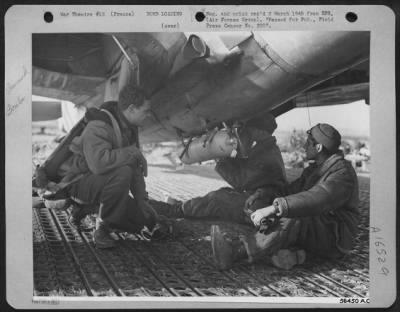 Thumbnail for General > At a 12th Tactical Air Command fighter-bomber base in France, a 100-lb. phophorous bomb is attached to the belly of a Republic P-47 Thunderbolt. Pilot, 2nd Lt. Wesly R. Izzard, 2805 Lipscord, Amarillo, Texas, at left, watches as S/Sgt. Albert