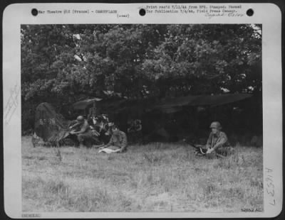 Thumbnail for General > With one crew member standing guard with a machine gun the others are busily camouflaging the small plane used near the front lines to spot artillery fire. Left to right are: Cpl. N.A. Atherton, Chicago, radio-man; Pvt. Peter Palermo, Plaquemine, La.