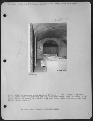 Thumbnail for General > A work table in a champagne cellar somewhere in France where the Germans set up shops for the manufacture and assembly of ignition, radio and armament items for German fighter craft. Through the archway is visible a large metal shield under which