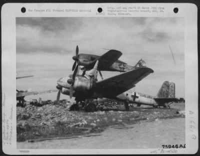 Thumbnail for General > A Member Of The 439Th Troop Carrier Looks Over A Captured German Junkers Piggy Back Plane [Junkers Ju 88 And Focke Wulf Fw 190] At An Air Base Somewhere In France.  4 May 1945.