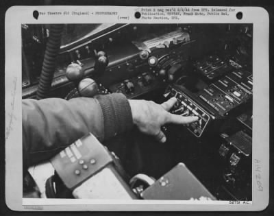 Thumbnail for Cameras,Gun > High over the target, Lt. Schultz, turns the switches that control the battery of automatic aerial cameras in the nose of his Lockheed P-38 Lightning, photo-reconnaissance plane. As he flies over the objective to be mapped, these cameras will make an