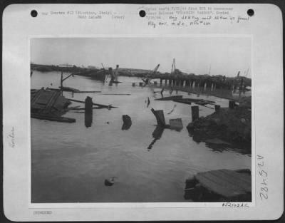 Thumbnail for Consolidated > Enemy ships lie wallowing in the river bed and the quay is a shambles after attack by bombers of the Mediterranean Allied Air Forces on the harbor and installations at Piombino, south of Leghorn on the Italian west coast. This close-up photo